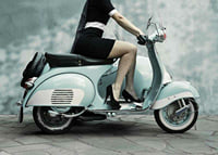Photograph of woman on light blue retro scooter against gray wall-7