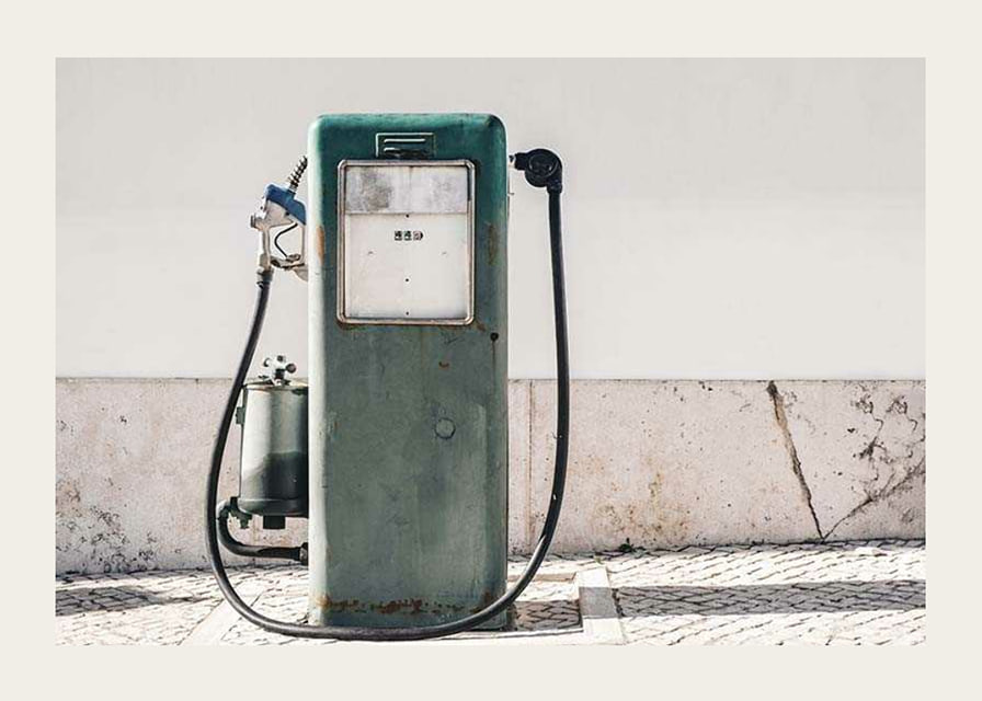 Fotografia de uma bomba de gasolina vintage verde contra uma parede clara-12