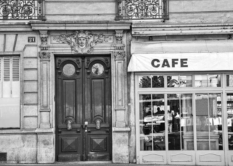 Black and white photo of classic Parisian cafe facade and gate-12