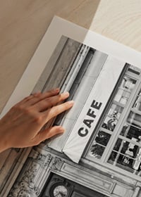 Black and white photo of classic Parisian cafe facade and gate-9