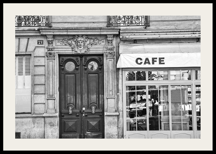 Black and white photo of classic Parisian cafe facade and gate-12