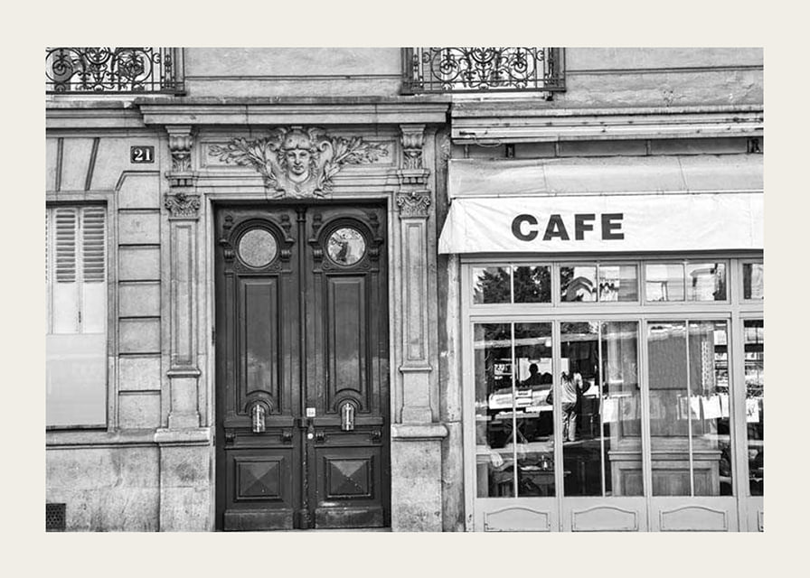 Black and white photo of classic Parisian cafe facade and gate-12