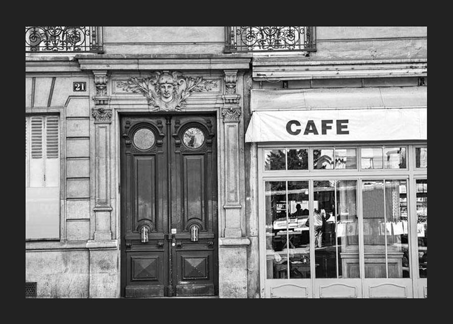 Black and white photo of classic Parisian cafe facade and gate-12