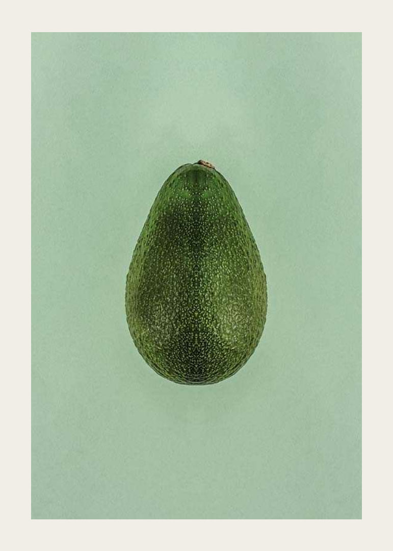 Photograph of whole green avocado against a solid green background-12