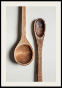 Two wooden spoons in close-up against light gray background, photographic-2