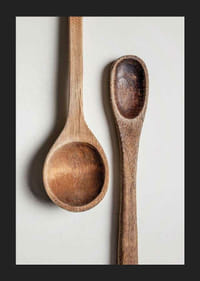 Two wooden spoons in close-up against light gray background, photographic-5