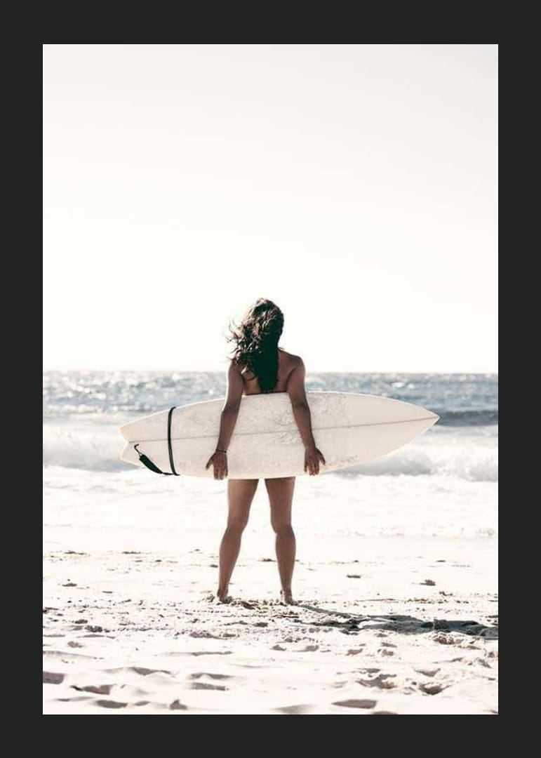Fotografia ženy so surfom na piesočnatej pláži pri mori-12
