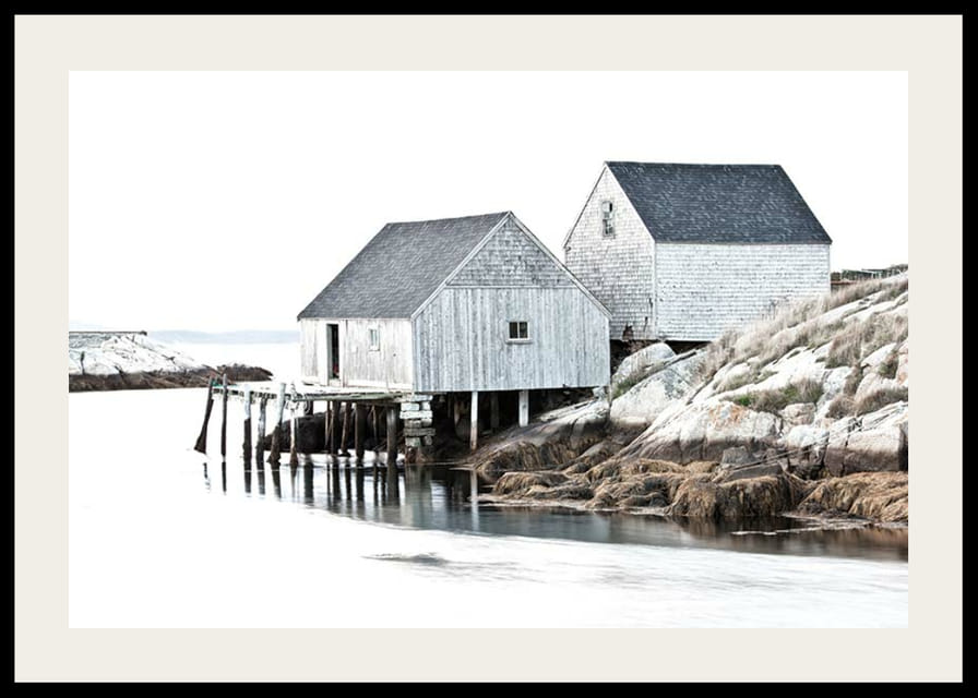 Fotografía de dos edificios de madera gris junto a los acantilados y el agua.-12