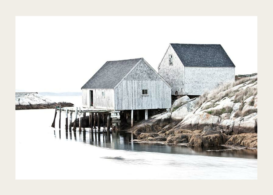 Fotografía de dos edificios de madera gris junto a los acantilados y el agua.-12