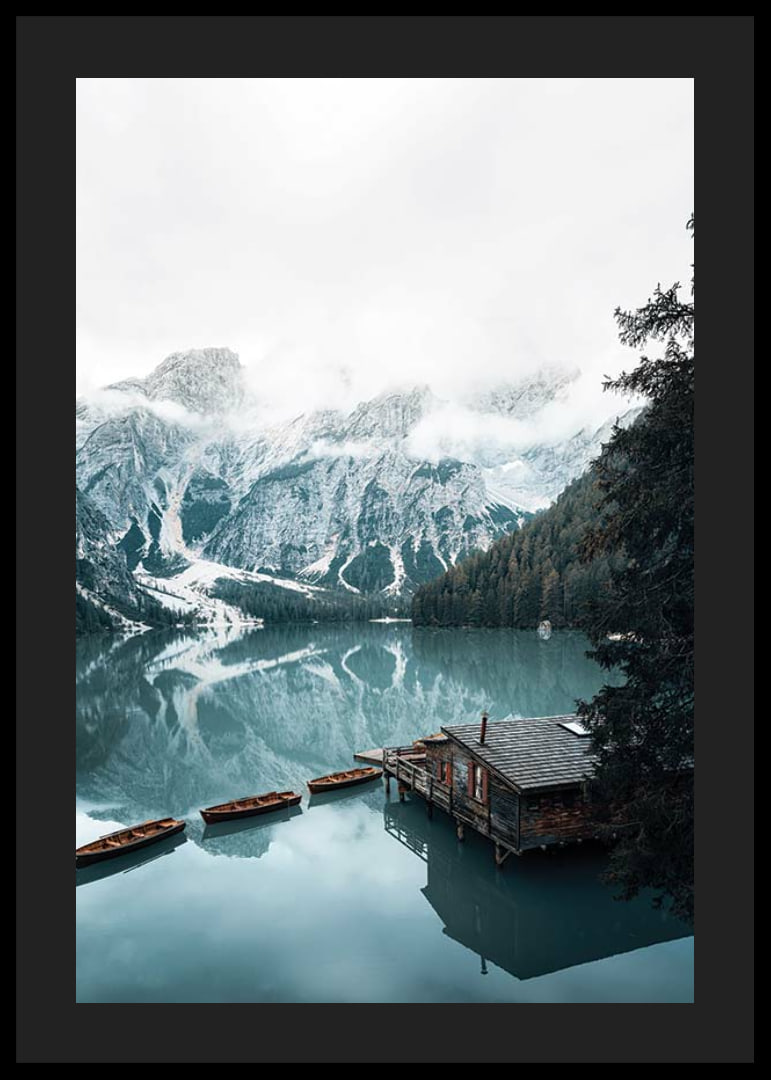 Photograph of snow-capped mountains, wooden pier and rowboats on a mirror-like lake-12