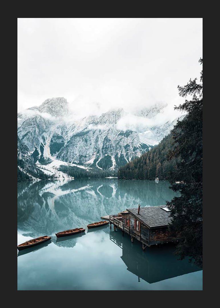 Photograph of snow-capped mountains, wooden pier and rowboats on a mirror-like lake-12