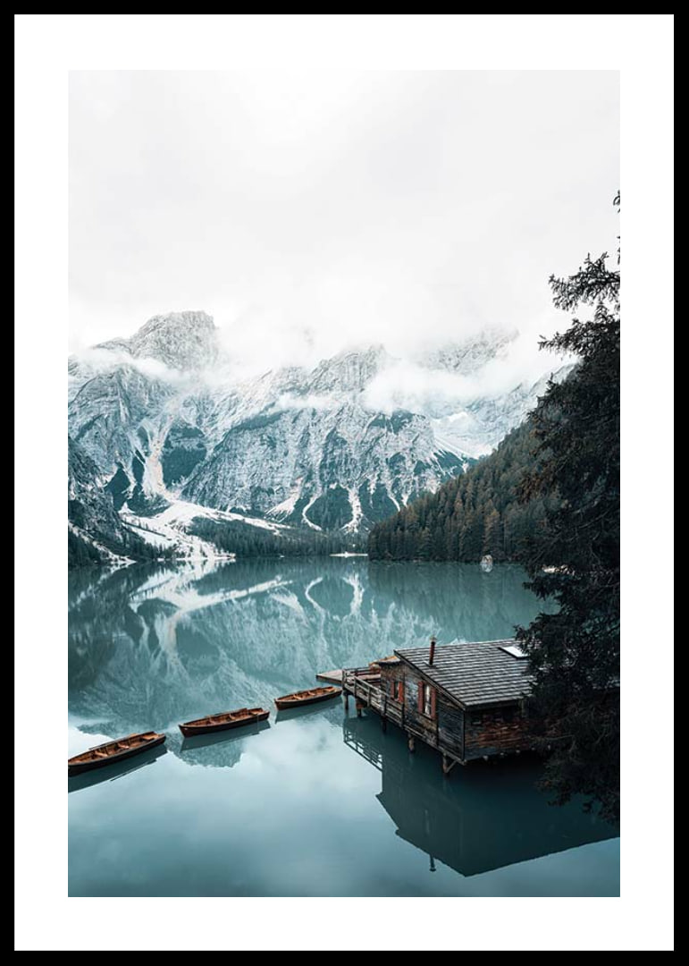 Photograph of snow-capped mountains, wooden pier and rowboats on a mirror-like lake-12