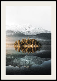 Fotografía de una pequeña isla boscosa en un lago cristalino con montañas cubiertas de nieve.-2