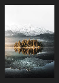 Fotografía de una pequeña isla boscosa en un lago cristalino con montañas cubiertas de nieve.-5
