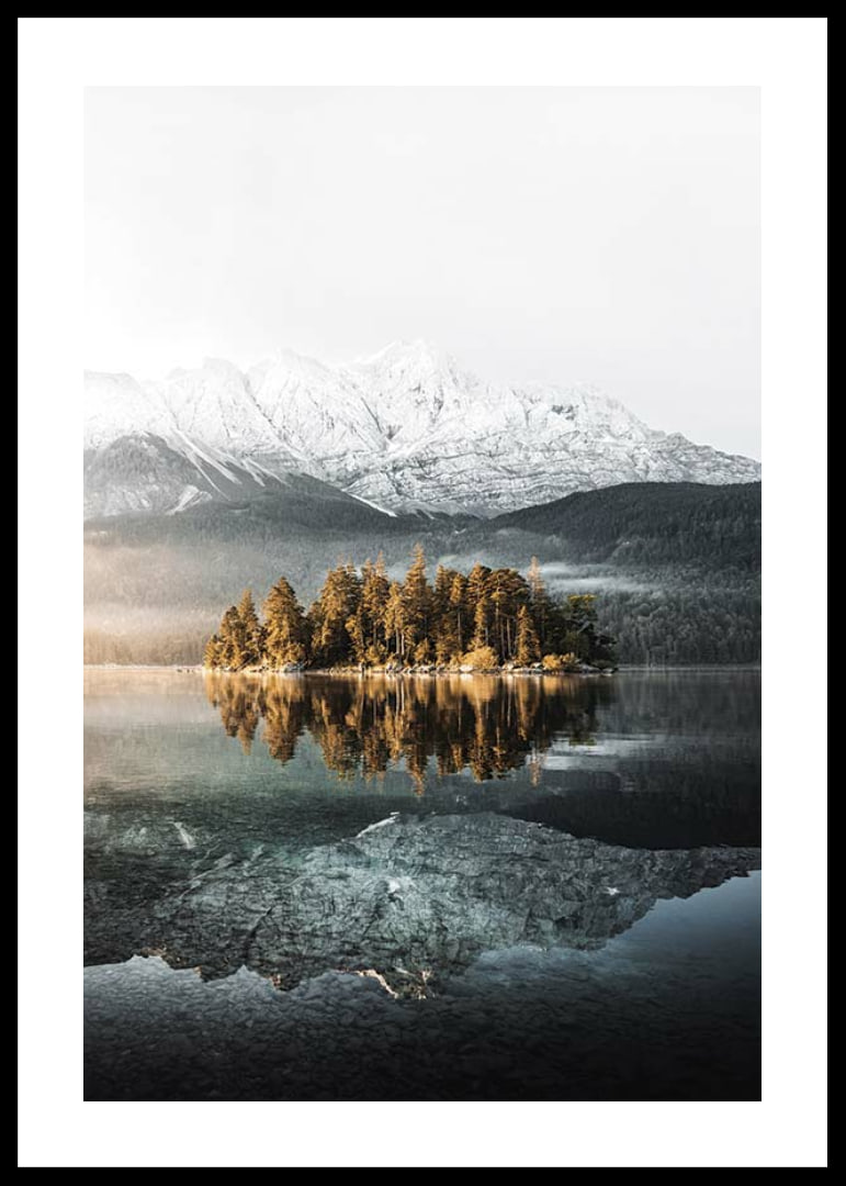 Fotografía de una pequeña isla boscosa en un lago cristalino con montañas cubiertas de nieve.-12