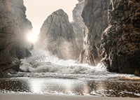 Photograph of waves crashing against rocks in soft backlight-7