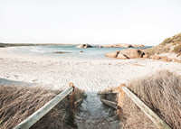 Fotografi av trappa ner till ljus sandstrand med hav och klippor-7