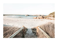 Fotografi av trappa ner till ljus sandstrand med hav och klippor-1