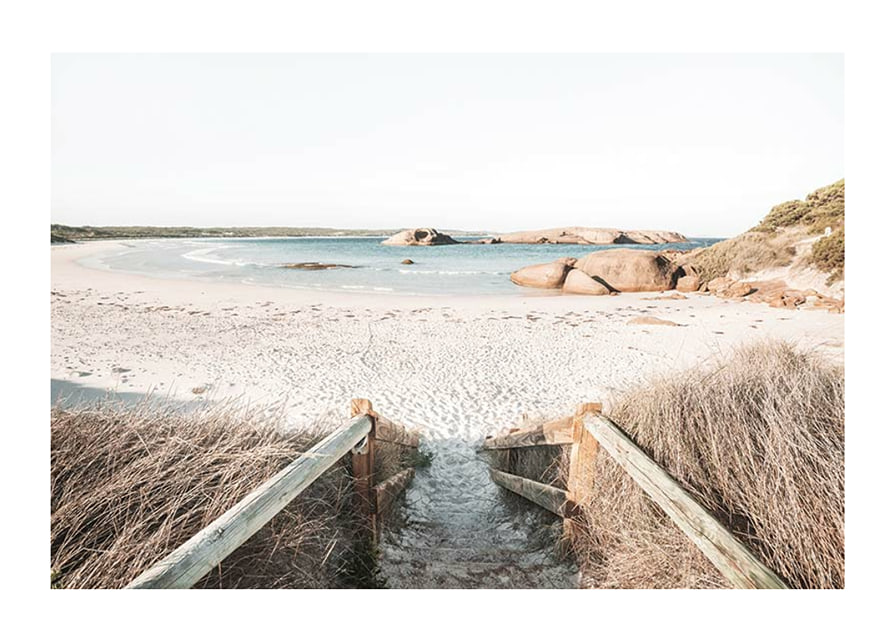 Fotografi av trappa ner till ljus sandstrand med hav och klippor-12
