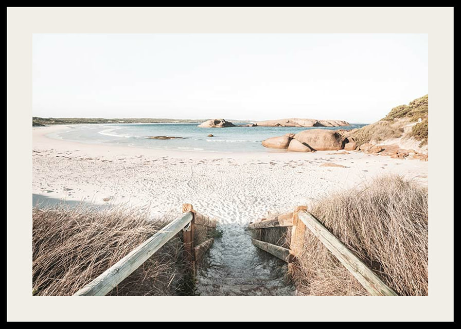 Fotografi av trappa ner till ljus sandstrand med hav och klippor-12