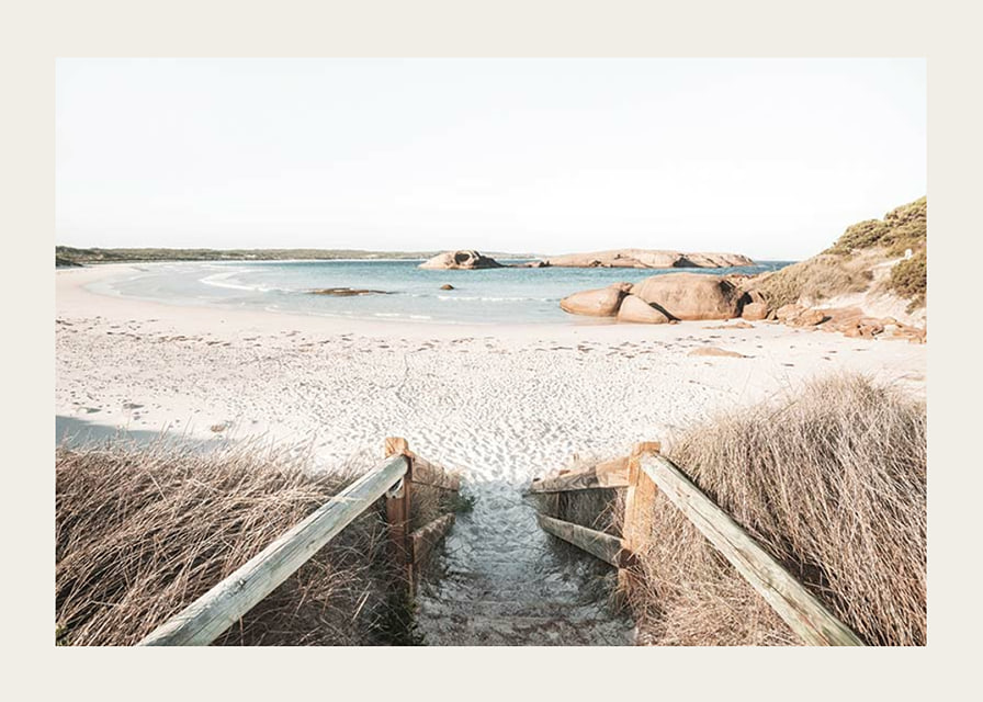 Fotografi av trappa ner till ljus sandstrand med hav och klippor-12