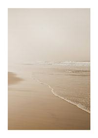Fotografi av lång strand med vågor i mjuka beige toner-1
