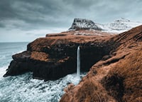 Fotografische Landschaft mit hohem Wasserfall an karger Küste-7