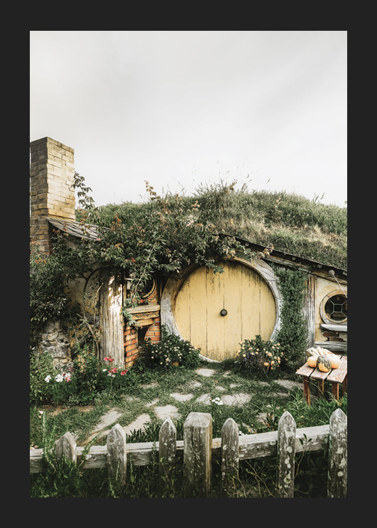 Casa hobbit erbosa con porta rotonda gialla e giardino fiorito-12