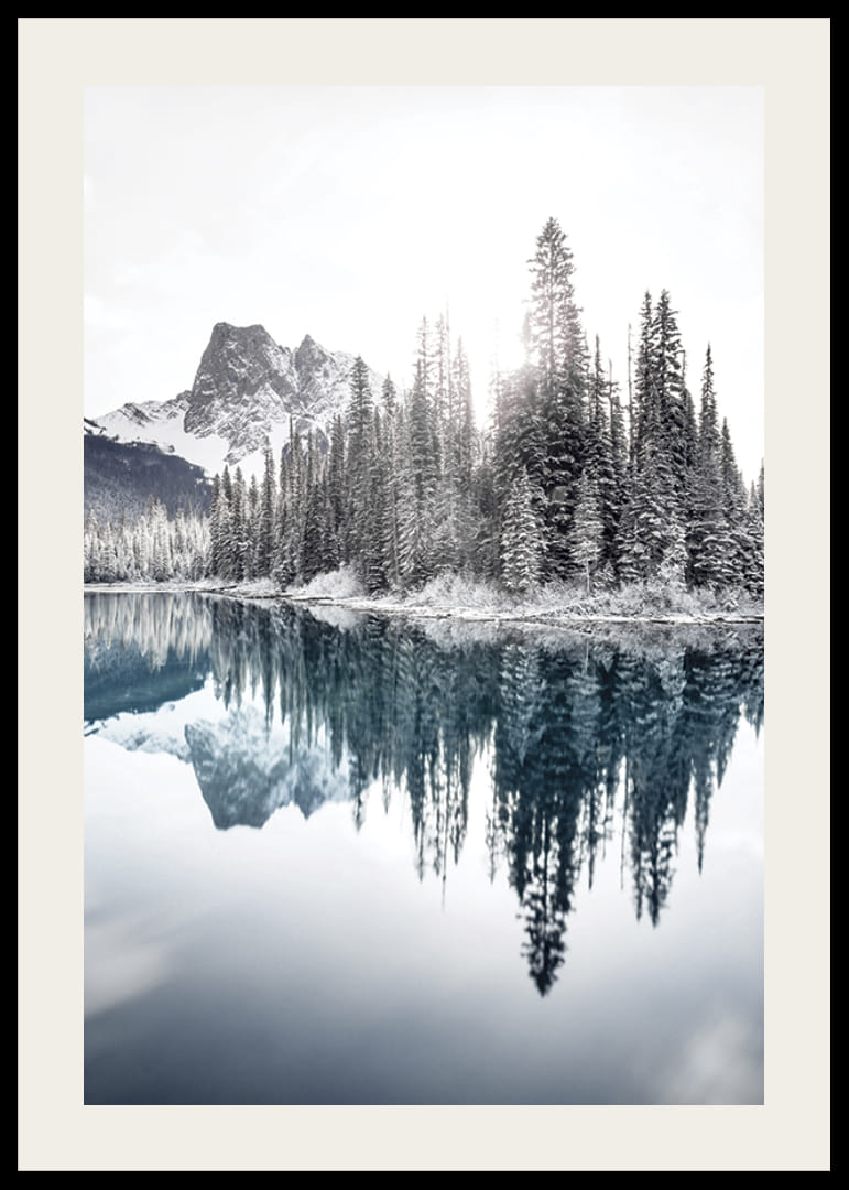 Valokuva lumipeitteisistä kuusista kirkkaan sinisen järven ja vuorten rannalla-12