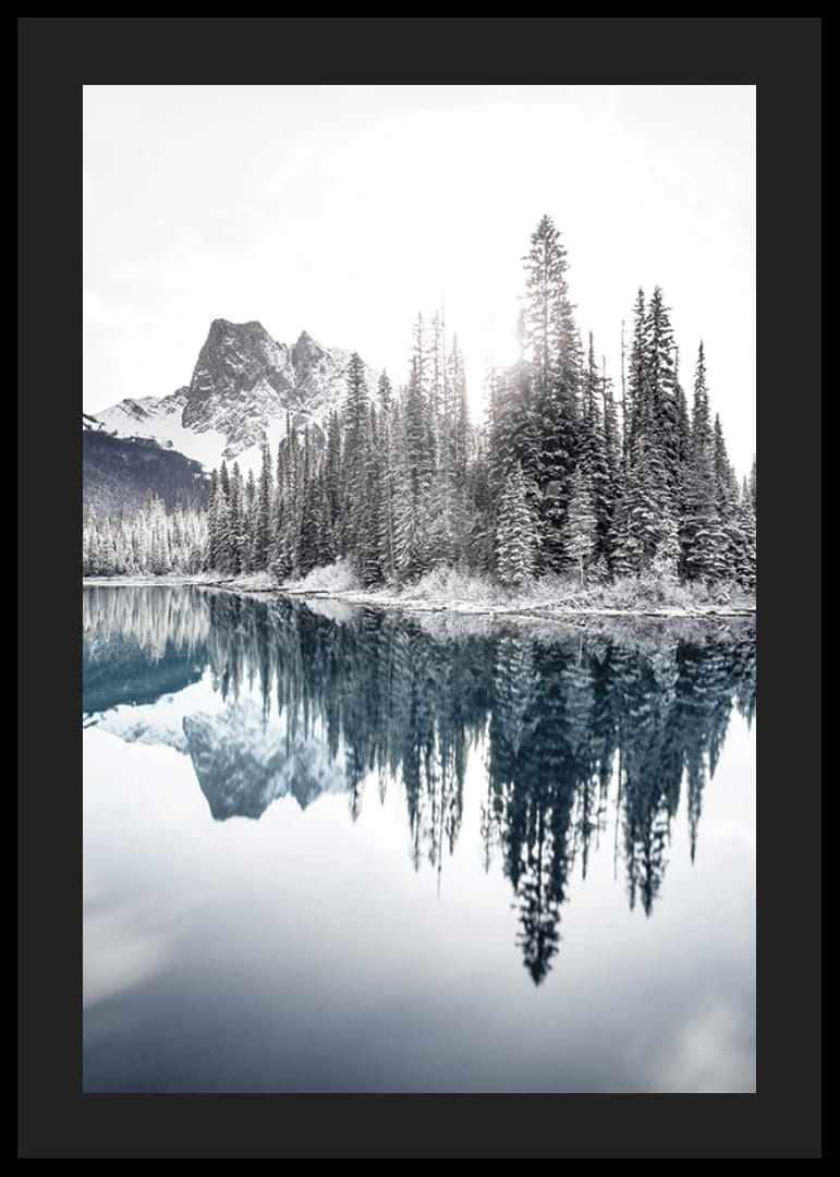 Valokuva lumipeitteisistä kuusista kirkkaan sinisen järven ja vuorten rannalla-12