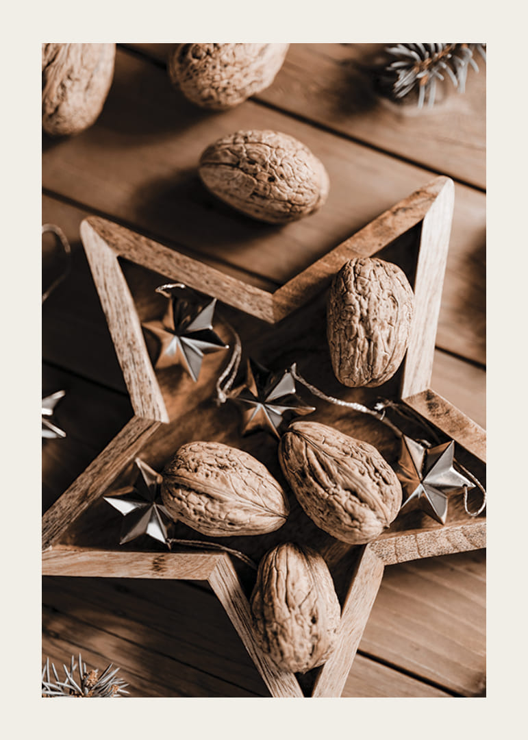 Walnüsse im Holzstern mit Metallsternen auf Holztisch-12