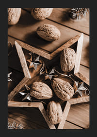 Walnüsse im Holzstern mit Metallsternen auf Holztisch-5