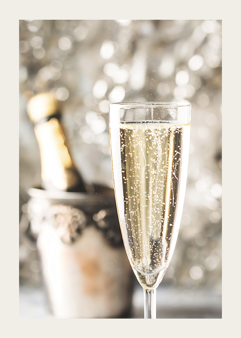 Fotografiskt närbild av champagneglas med bubblor och suddig flaska i bakgrunden-12