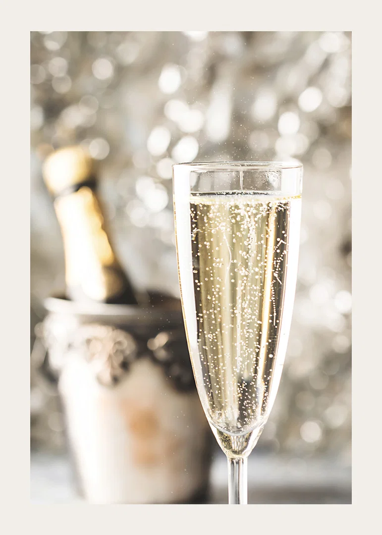 Photographic close-up of champagne glass with bubbles and blurred bottle in the background-12