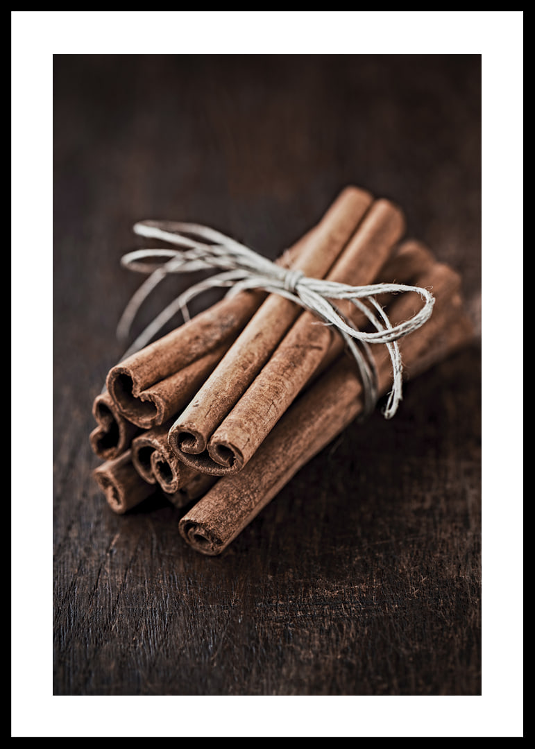 Close-up of cinnamon sticks in a bundle on dark wooden table-12