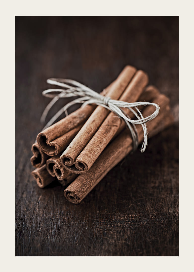 Nærbillede af kanelstænger i et bundt på mørkt træbord-12