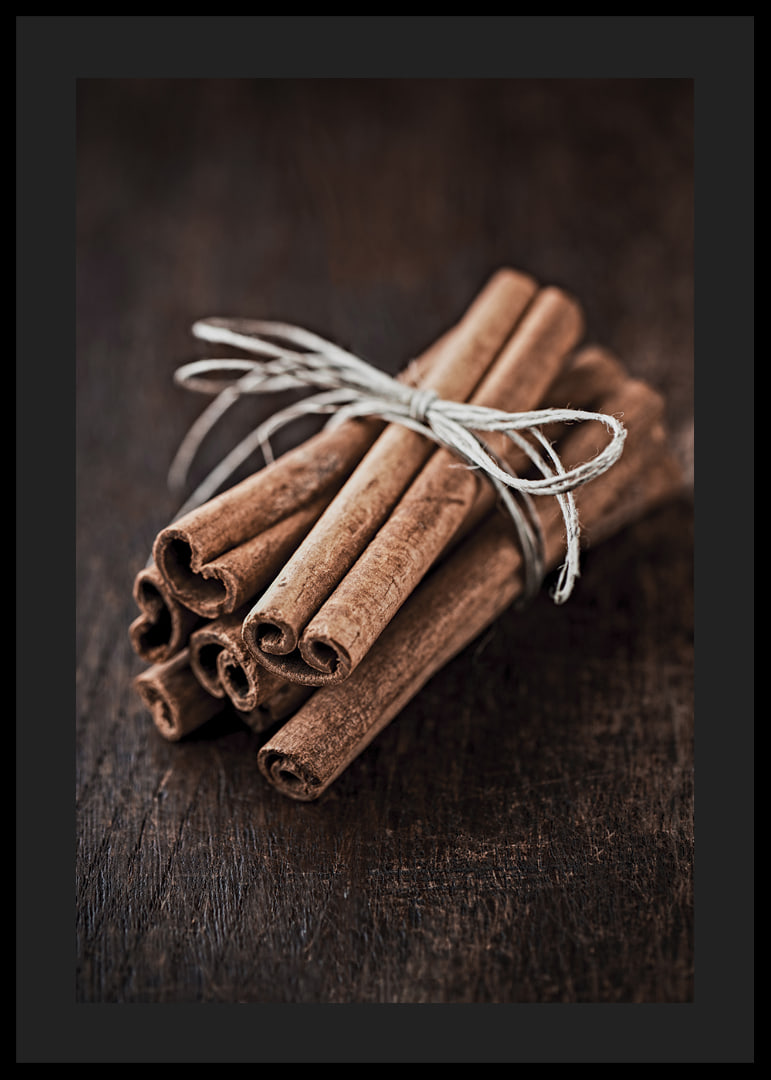 Close-up of cinnamon sticks in a bundle on dark wooden table-12