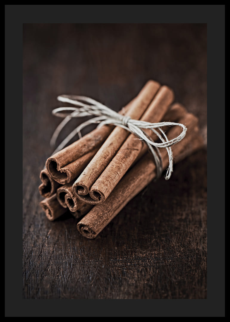 Nærbillede af kanelstænger i et bundt på mørkt træbord-12