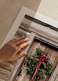 Fotografi av julkrans med röd rosett på träfärgad dörr-9