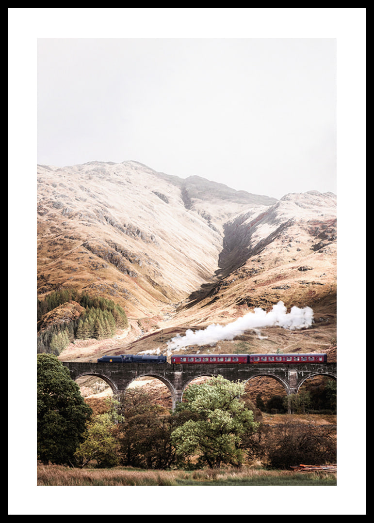 Steam train on stone viaduct in front of bright mountains in autumn landscape-12