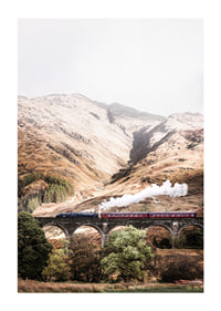 Steam train on stone viaduct in front of bright mountains in autumn landscape-1