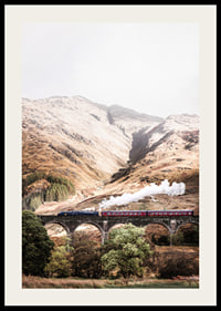 Steam train on stone viaduct in front of bright mountains in autumn landscape-2
