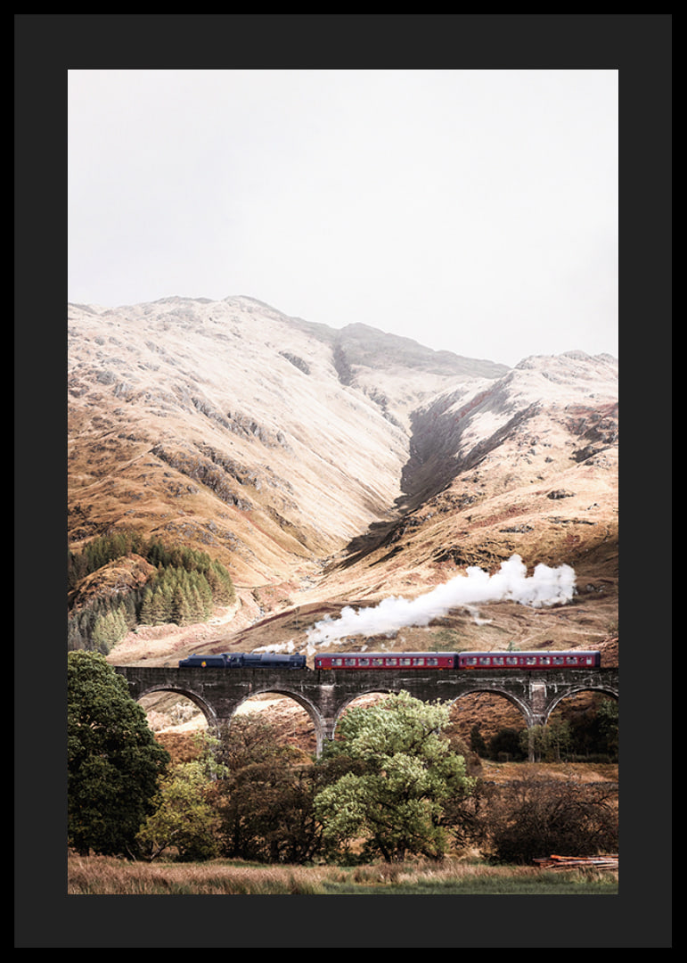 Steam train on stone viaduct in front of bright mountains in autumn landscape-12
