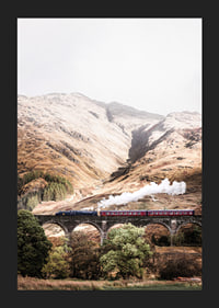 Steam train on stone viaduct in front of bright mountains in autumn landscape-5