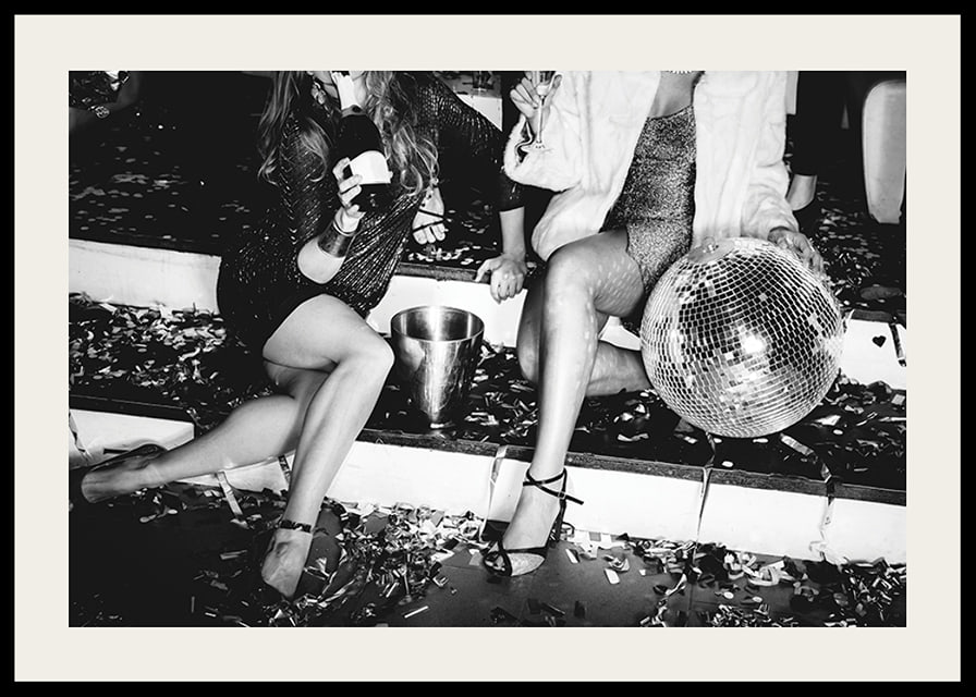 Black and white photograph of two women on party stairs with disco ball-12