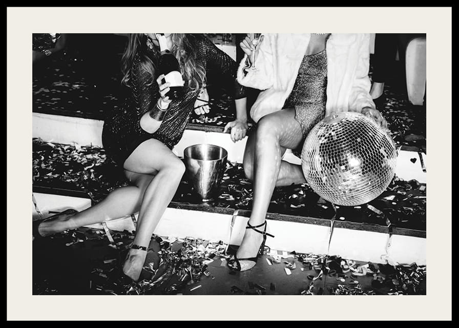 Fekete-fehér fénykép két nőről a buli lépcsőjén diszkógömbbel-12