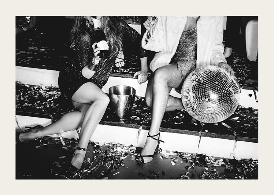 Black and white photograph of two women on party stairs with disco ball-12