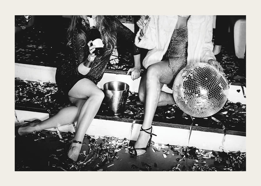 Fekete-fehér fénykép két nőről a buli lépcsőjén diszkógömbbel-12