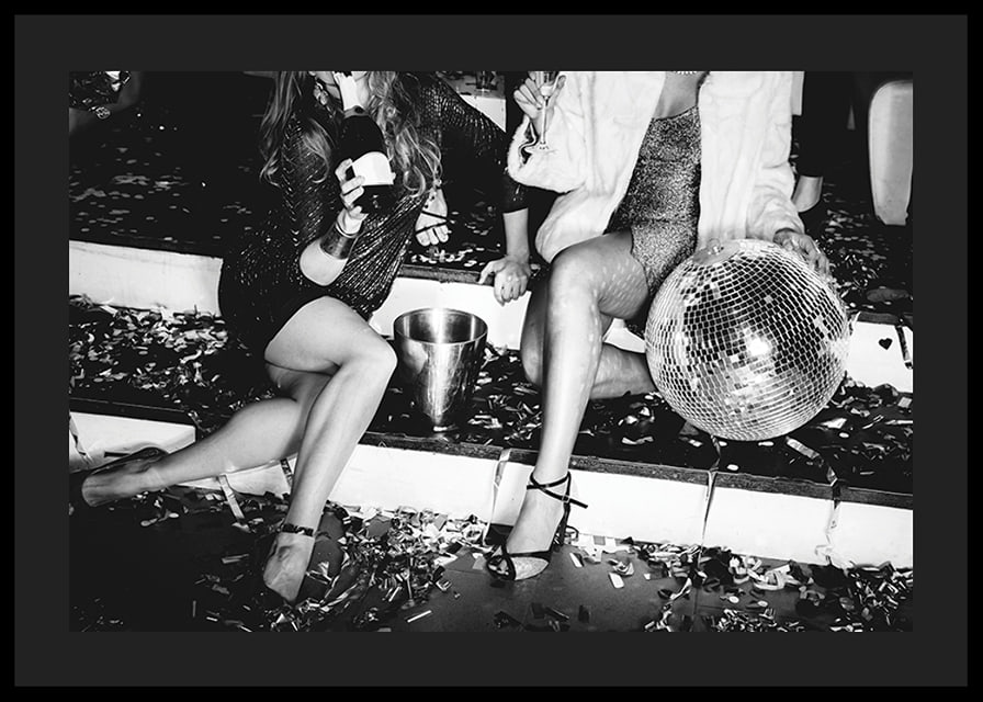 Black and white photograph of two women on party stairs with disco ball-12