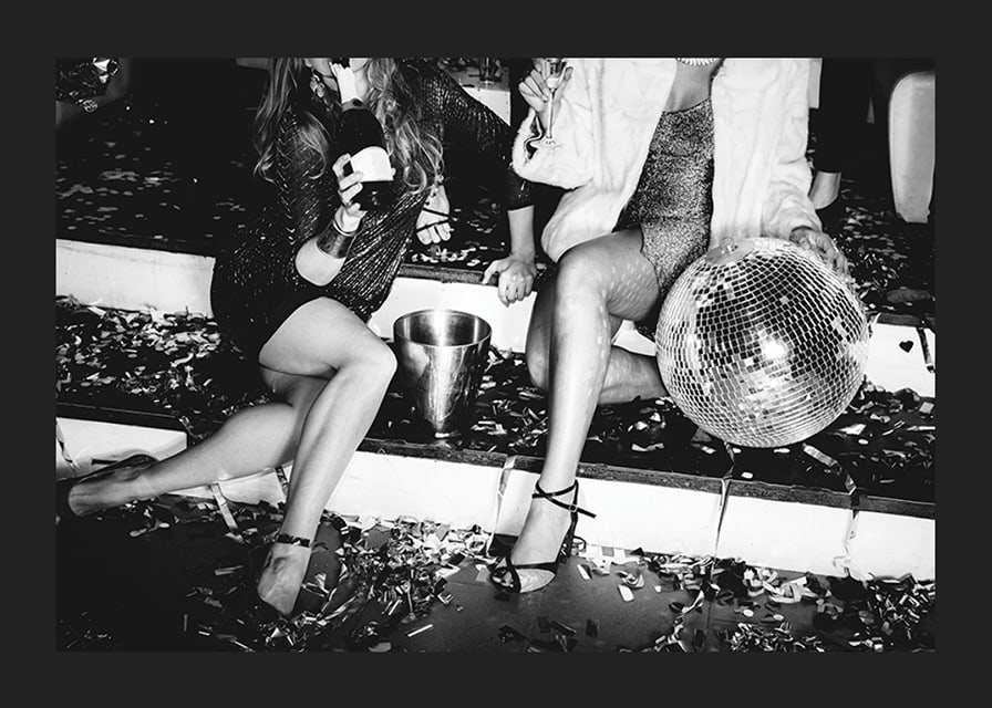 Black and white photograph of two women on party stairs with disco ball-12